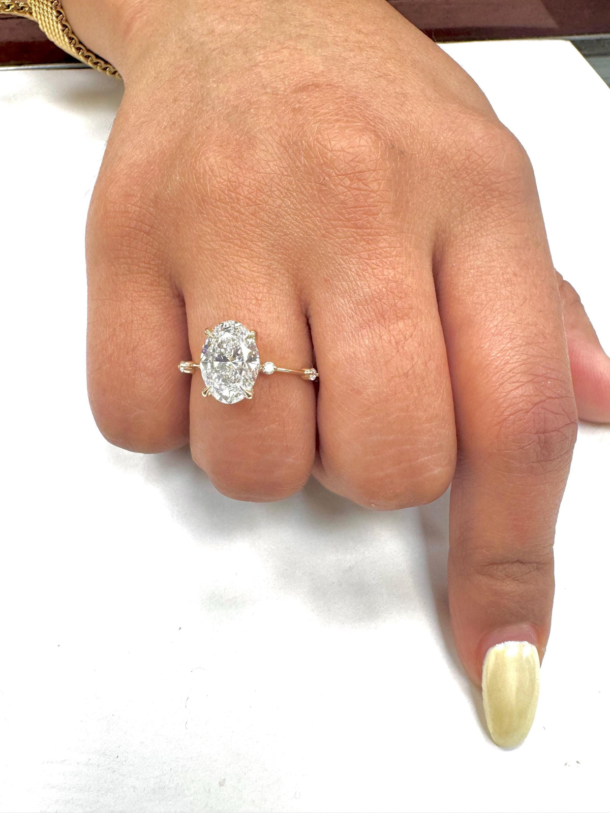 Close-up of a hand wearing a diamond ring on a white background