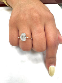 Close-up of a hand wearing a diamond ring on a white background