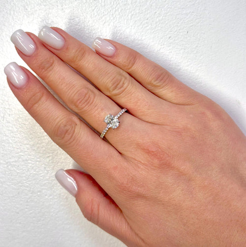 Hand wearing a diamond ring on a white background