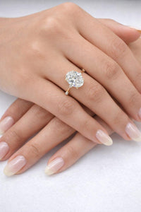 Close-up of a hand wearing a diamond ring on a white background